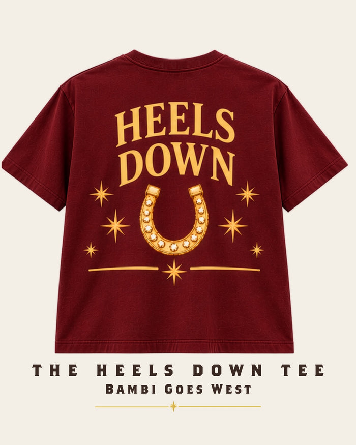 The Heels Down Tee in burgundy, back: Heels Down over a gold horseshoe with three stars.