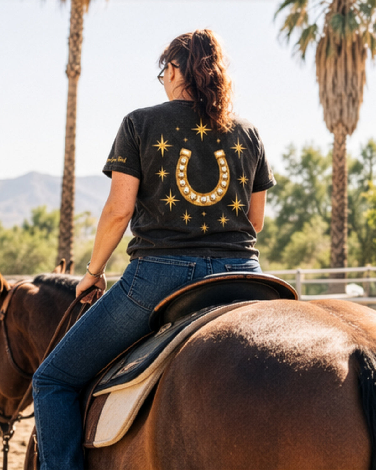Icon Tee in black, back, worn on horseback.